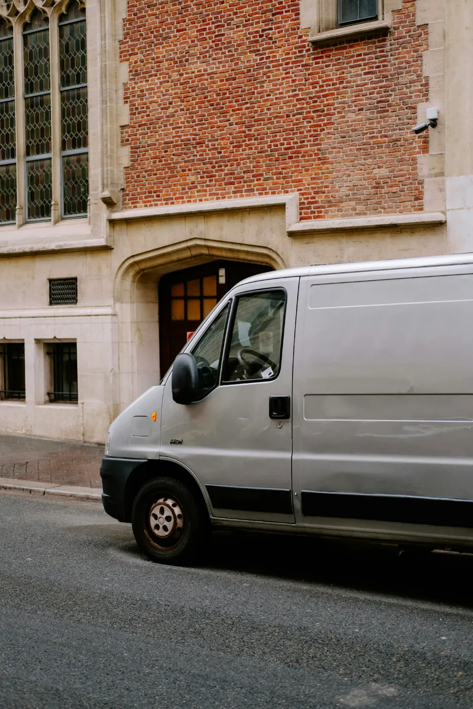 Furgone bianco per le consegne parcheggiato davanti a un palazzo